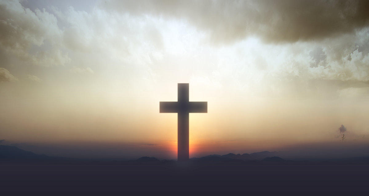 adobe-client-cross Cross standing with a beautiful sunset in the background